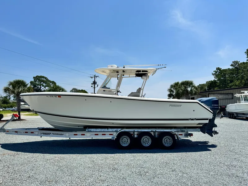 Slide: The Image of 2010 Pursuit C 280 Center Console boat on trailer, parked outdoors under clear blue sky. - 5