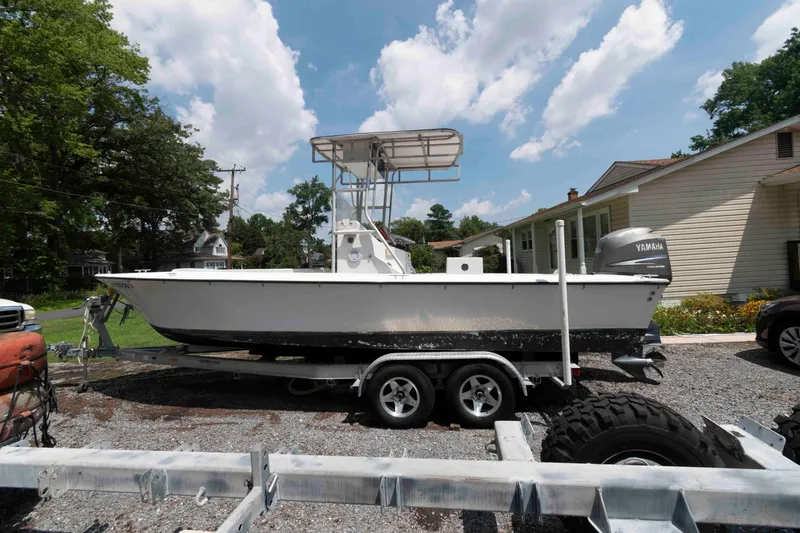 The Image of 1999 Custom High Seas Pumpout Boat on trailer, parked outdoors under a sunny sky. - 1