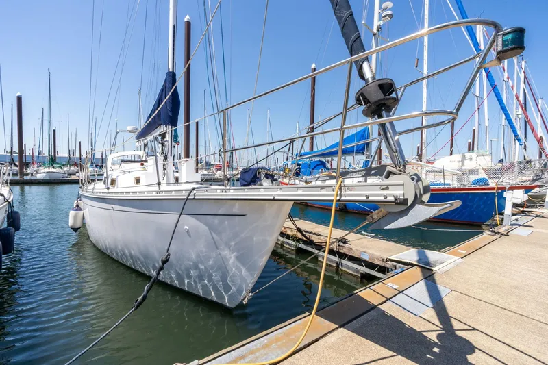 Slide: The Image of 1978 Cascade High Side sailboat docked in marina, clear sky, multiple masts visible. - 1