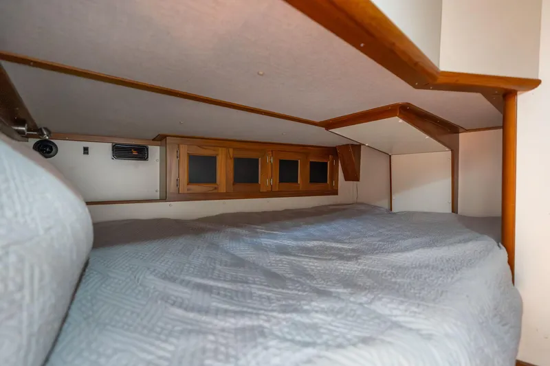 Slide: The Image of Cozy 1978 Cascade High Side camper interior with wooden cabinets and a comfortable bed. - 10