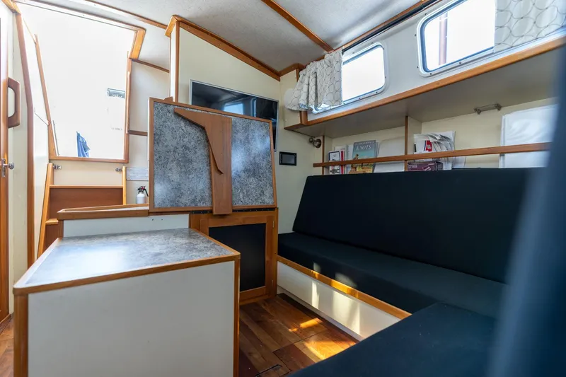 Slide: The Image of 1978 Cascade High Side boat interior with seating, table, and windows. - 12
