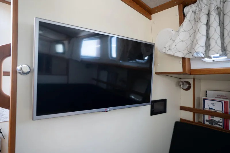 Slide: The Image of Flat-screen TV in a 1978 Cascade High Side boat interior with wooden accents. - 14