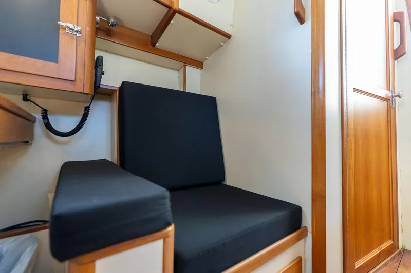 Slide: The Image of Interior of a 1978 Cascade Hign Side boat with black cushioned seating and wooden cabinetry. - 15