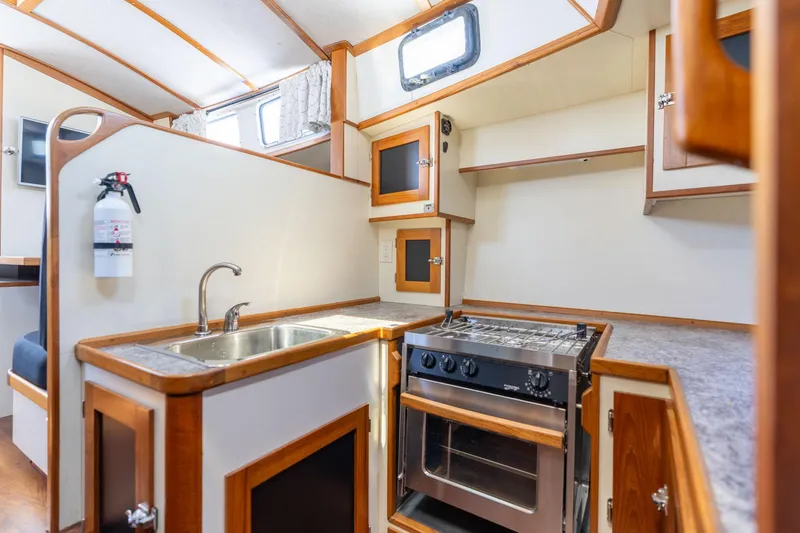 Slide: The Image of 1978 Cascade High Side boat kitchen with stove, sink, and wooden cabinetry. - 19