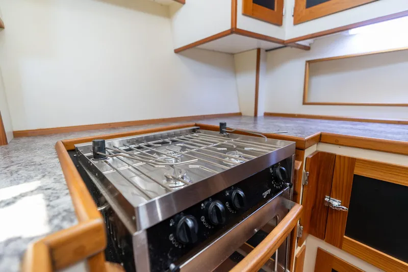 Slide: The Image of 1978 Cascade High Side kitchen with stainless steel stove and wooden cabinetry. - 21