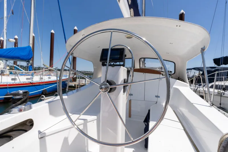 Slide: The Image of 1978 Cascade High Side sailboat cockpit with steering wheel, docked in marina. - 36
