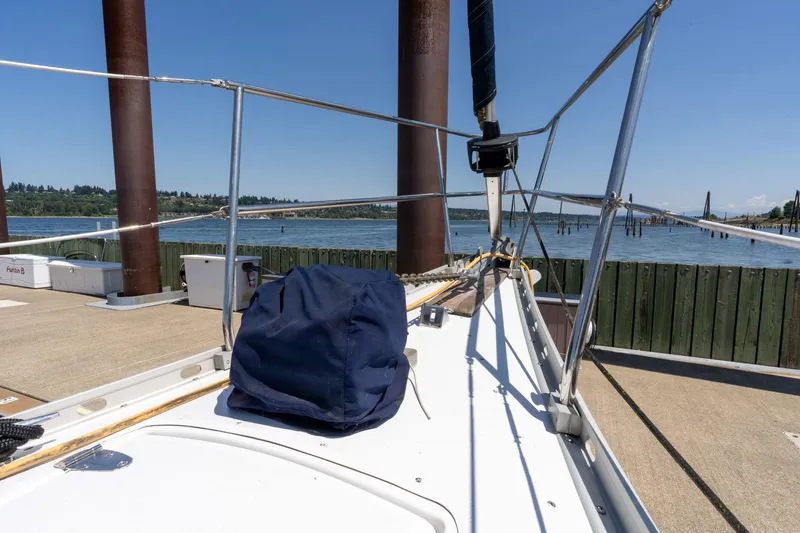 Slide: The Image of 1978 Cascade High Side sailboat docked by a scenic waterfront on a sunny day. - 49