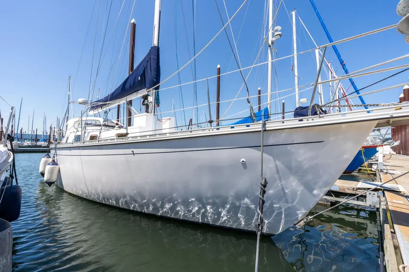 The Image of 1978 Cascade High Side sailboat docked in marina, clear blue sky background. - 0