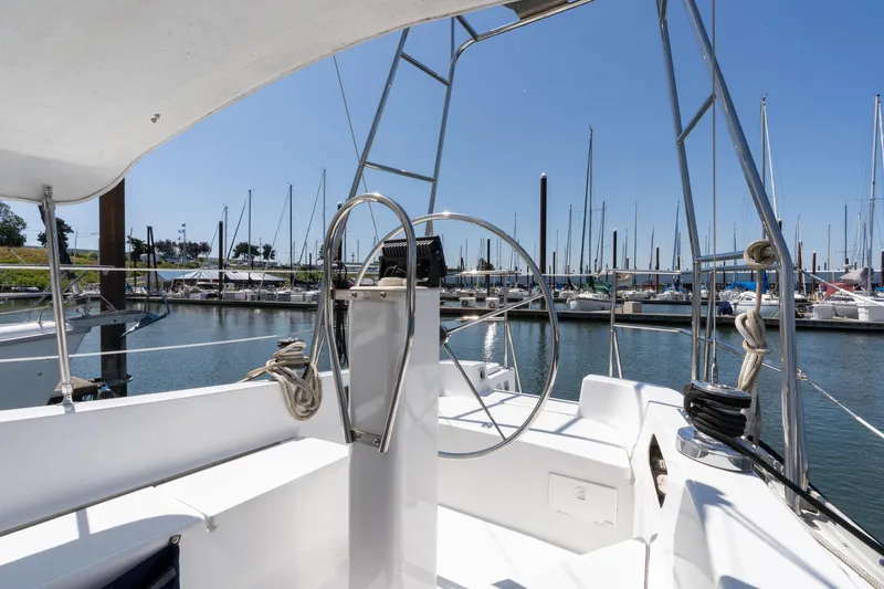 Slide: The Image of 1978 Cascade High Side sailboat cockpit with marina view, featuring steering wheel and moored boats. - 35