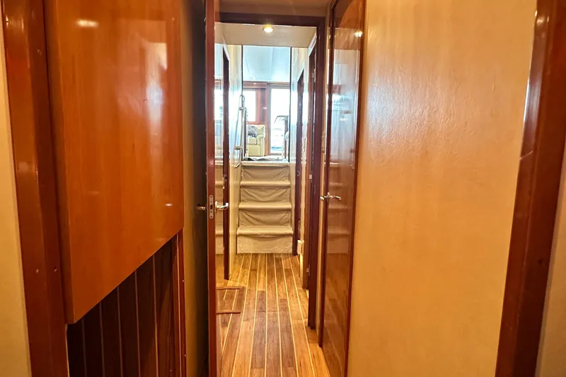 Slide: The Image of Hallway inside 2002 Hatteras 50 Convertible Sportfish yacht, featuring wooden doors and flooring. - 107