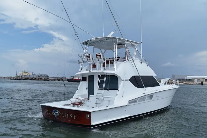 Slide: The Image of 2002 Hatteras 50 Convertible Sportfish yacht on water, with fishing rods and clear sky. - 12
