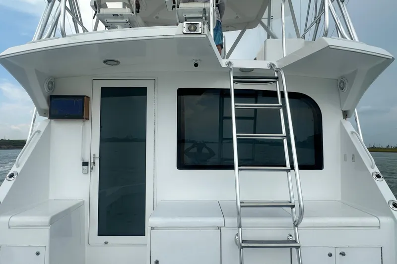Slide: The Image of 2002 Hatteras 50 Convertible Sportfish yacht with ladder and sleek white exterior. - 18
