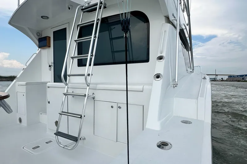 Slide: The Image of 2002 Hatteras 50 Convertible Sportfish yacht with ladder and ocean view. - 19