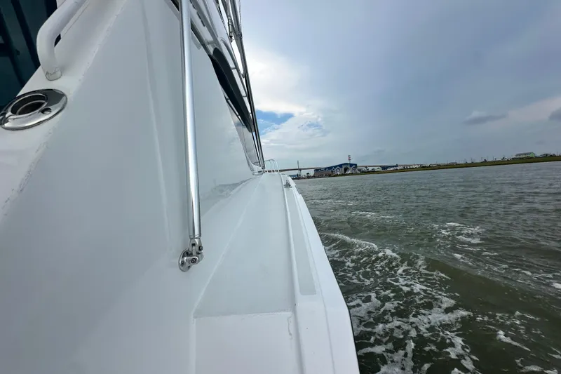 Slide: The Image of Side view of 2002 Hatteras 50 Convertible Sportfish cruising on water. - 20