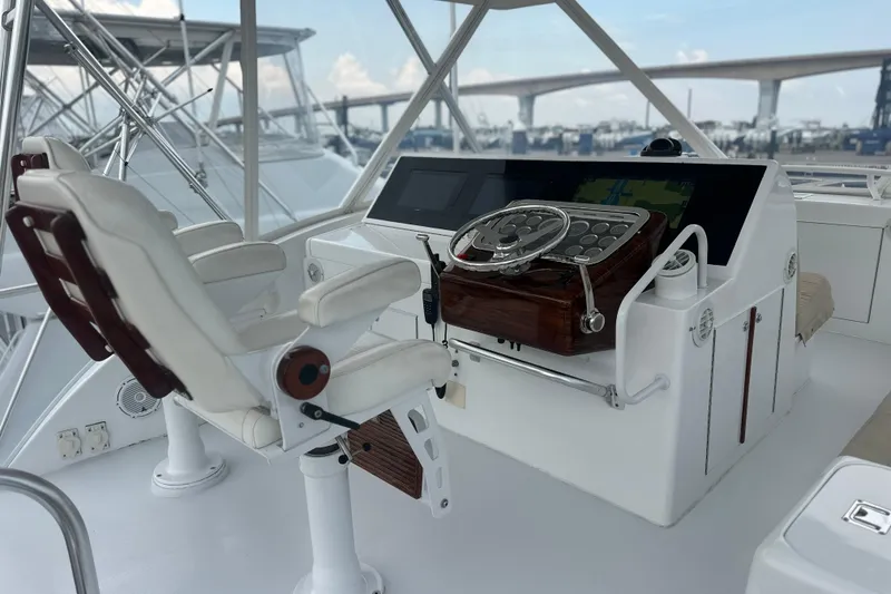 Slide: The Image of Helm of 2002 Hatteras 50 Convertible Sportfish with steering wheel and navigation controls. - 23