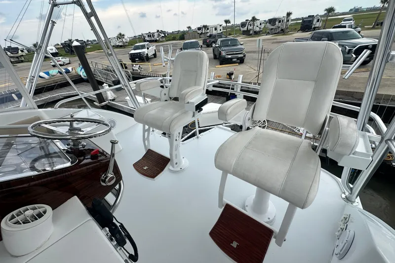 Slide: The Image of Helm of 2002 Hatteras 50 Convertible Sportfish with two white captain chairs. - 25