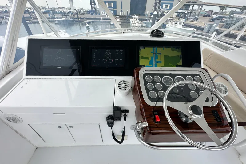 Slide: The Image of Helm of 2002 Hatteras 50 Convertible Sportfish with navigation screens and steering wheel. - 26