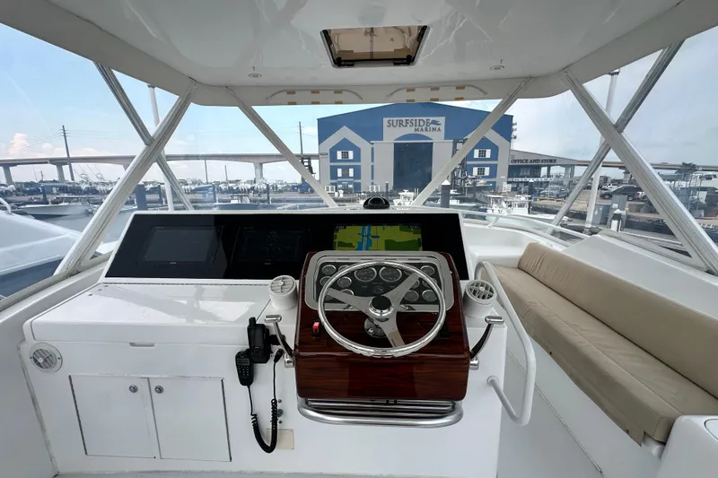 Slide: The Image of Helm of 2002 Hatteras 50 Convertible Sportfish at marina, featuring steering wheel and navigation equipment. - 28