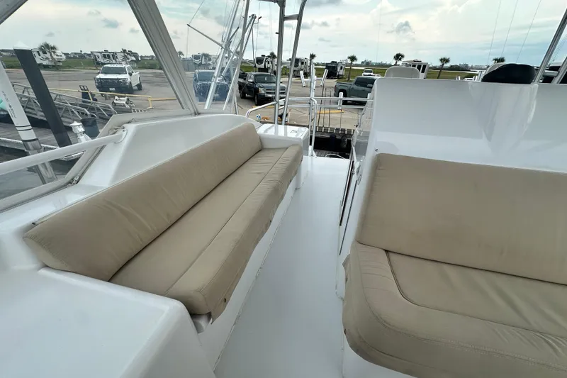 Slide: The Image of 2002 Hatteras 50 Convertible Sportfish interior with beige seating and marina view. - 37