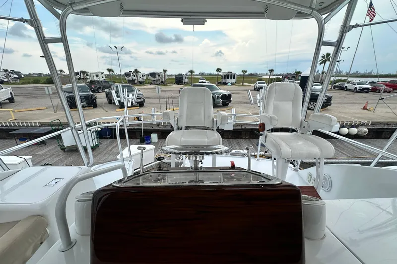 Slide: The Image of 2002 Hatteras 50 Convertible Sportfish yacht cockpit with helm chairs and marina view. - 40