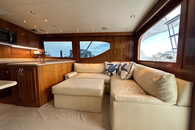 Slide: The Image of Luxurious interior of 2002 Hatteras 50 Convertible Sportfish with plush seating and wooden cabinetry. - 52