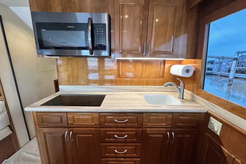 Slide: The Image of Luxurious kitchen in 2002 Hatteras 50 Convertible Sportfish yacht with modern appliances and wood cabinetry. - 60