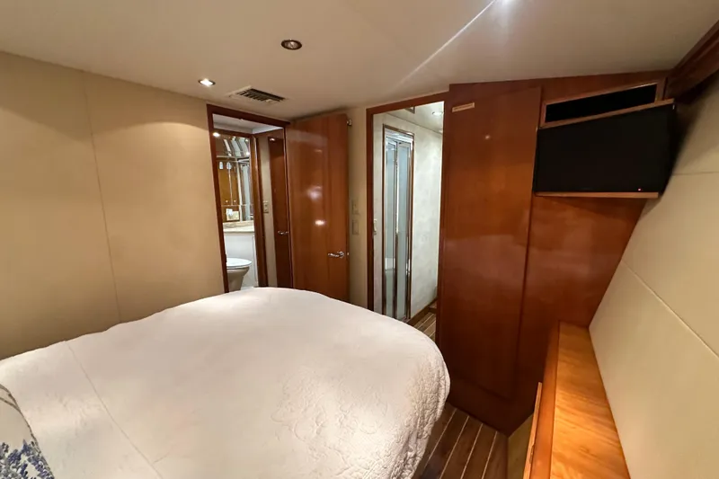 Slide: The Image of Interior of 2002 Hatteras 50 Convertible Sportfish, featuring a cozy bedroom with ensuite bathroom. - 73