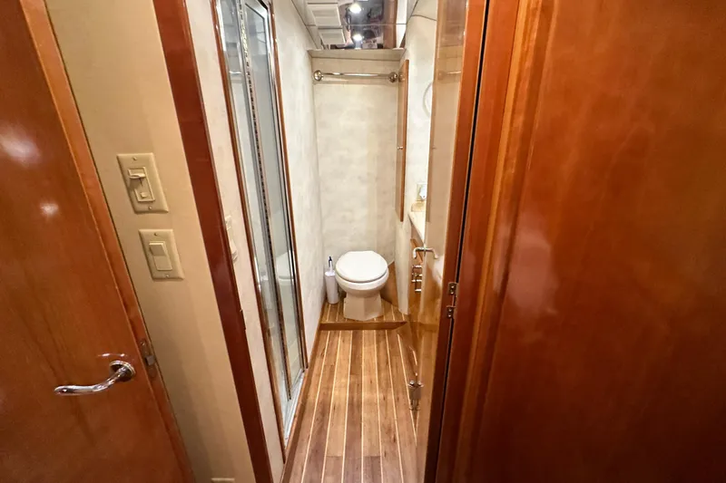 Slide: The Image of Bathroom interior of 2002 Hatteras 50 Convertible Sportfish yacht, featuring wood accents and modern fixtures. - 76
