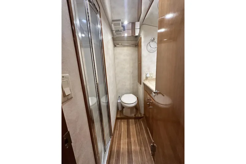 Slide: The Image of Bathroom interior of 2002 Hatteras 50 Convertible Sportfish with wood flooring and shower. - 77