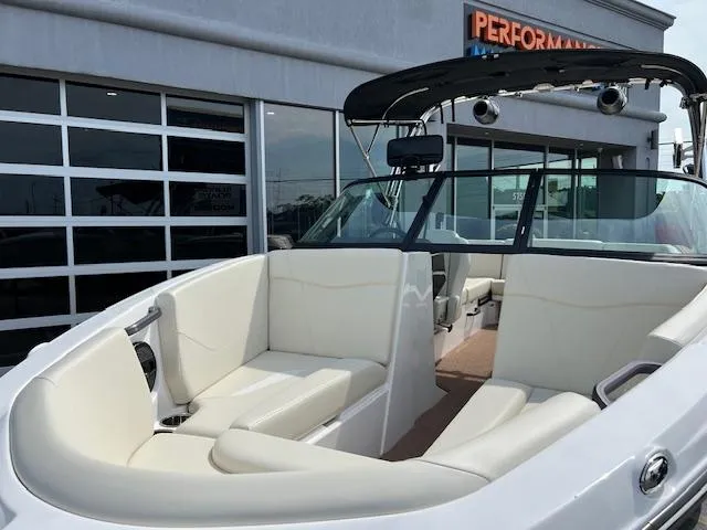 Slide: The Image of 2025 MasterCraft NXT23 boat with white interior, docked near a showroom. - 10