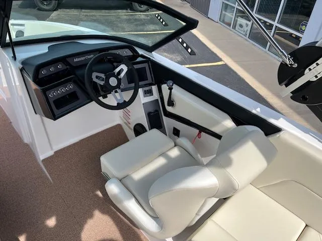 Slide: The Image of 2025 MasterCraft NXT23 boat interior with modern dashboard and comfortable seating. - 12