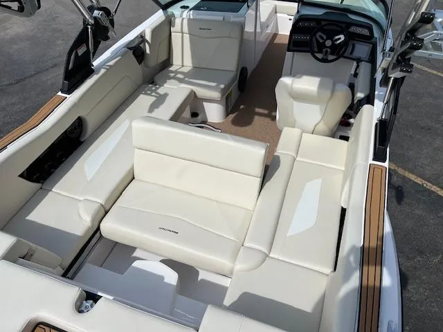 Slide: The Image of 2025 MasterCraft NXT23 boat interior with luxurious white seating and modern dashboard. - 18