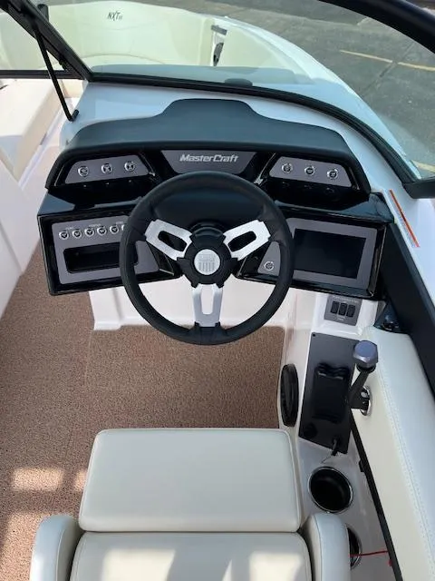 Slide: The Image of 2025 MasterCraft NXT23 boat dashboard with steering wheel and control panel. - 22