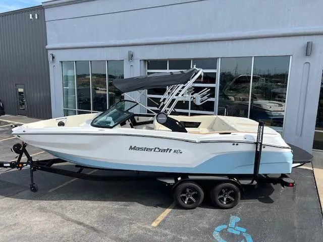 Slide: The Image of 2025 MasterCraft NXT23 boat on trailer outside dealership. - 3