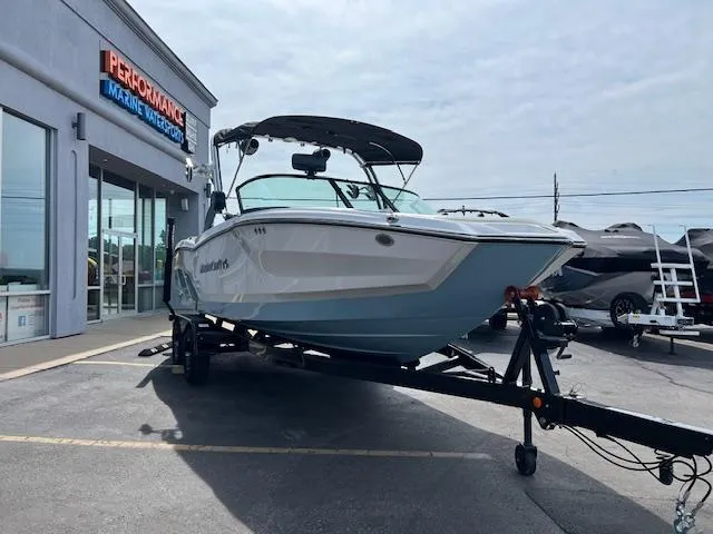 Slide: The Image of 2025 MasterCraft NXT23 boat on trailer outside marine dealership. - 8