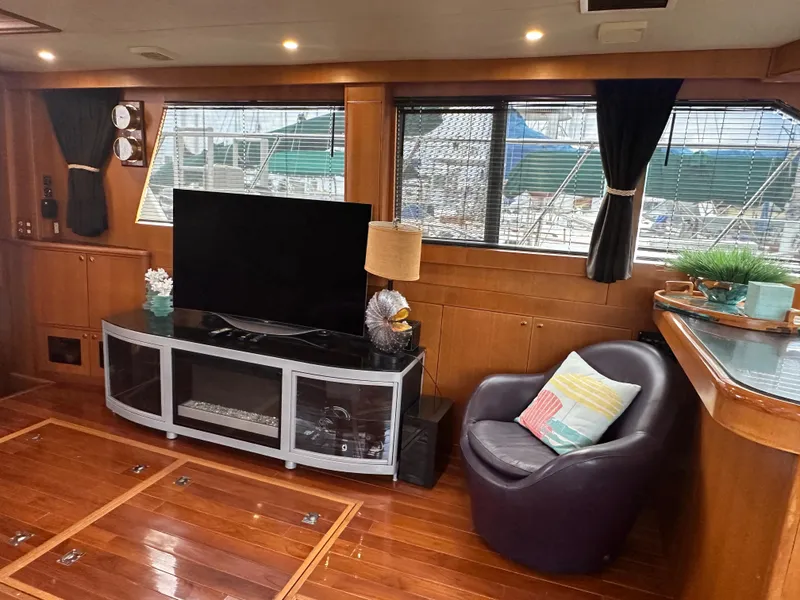 Slide: The Image of Luxurious 2005 Jefferson Rivanna 50 SDMY yacht interior with TV, armchair, and wooden flooring. - 24