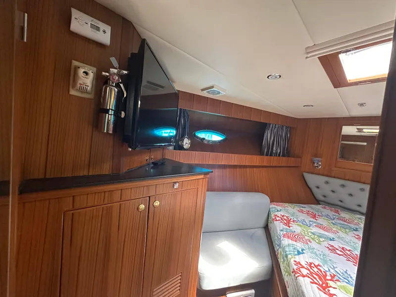 Slide: The Image of 2005 Jefferson Rivanna 50 SDMY yacht cabin with wood paneling, bed, and TV. - 45