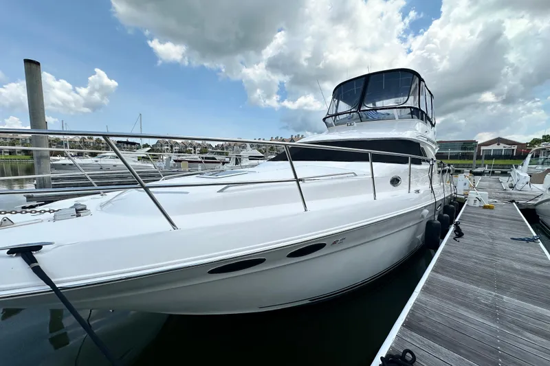 Slide: The Image of 2001 Sea Ray 400 Sedan Bridge yacht docked at marina under cloudy sky. - 10