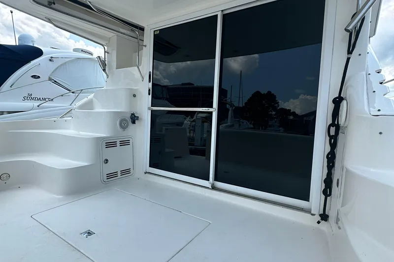 Slide: The Image of 2001 Sea Ray 400 Sedan Bridge yacht deck with sliding glass door and seating area. - 12