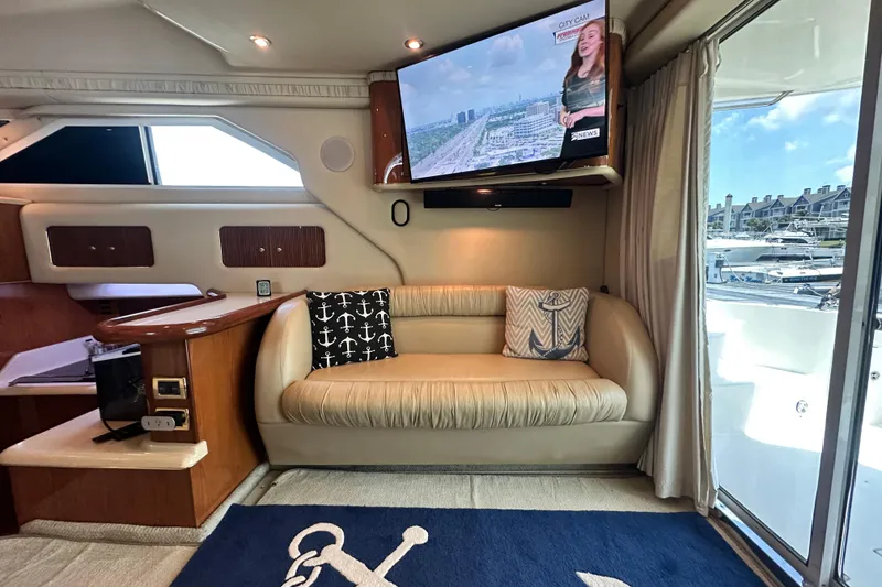Slide: The Image of Interior of 2001 Sea Ray 400 Sedan Bridge yacht with sofa, TV, and marina view. - 16