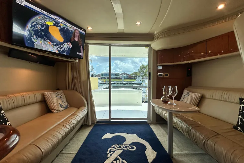 Slide: The Image of Interior of 2001 Sea Ray 400 Sedan Bridge with TV, seating, and marina view. - 21