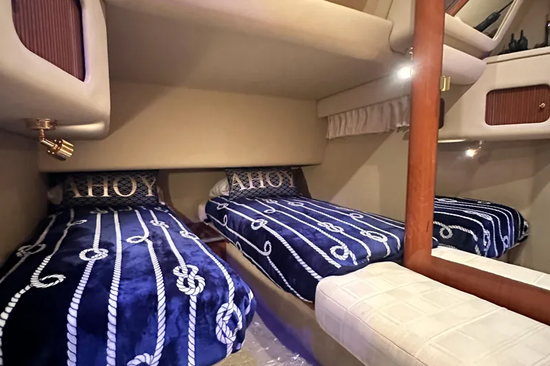 Slide: The Image of Interior cabin of 2001 Sea Ray 400 Sedan Bridge with nautical-themed bedding. - 36