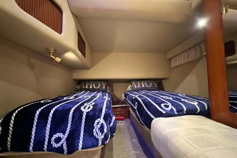 Slide: The Image of Interior cabin of 2001 Sea Ray 400 Sedan Bridge with nautical-themed bedding. - 37