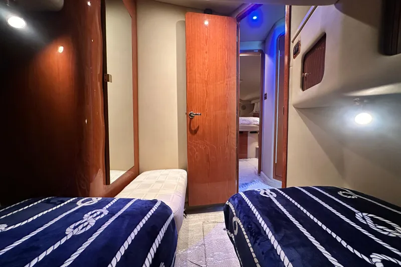 Slide: The Image of Interior of 2001 Sea Ray 400 Sedan Bridge with twin beds and nautical decor. - 39