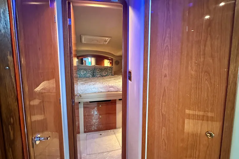 Slide: The Image of Interior cabin view of 2001 Sea Ray 400 Sedan Bridge yacht, featuring wood paneling and cozy bedding. - 41