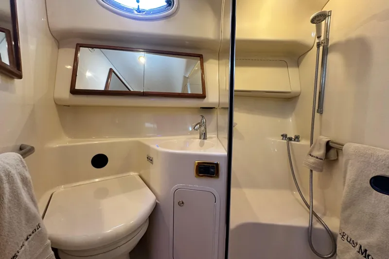 Slide: The Image of 2001 Sea Ray 400 Sedan Bridge bathroom with shower, sink, and mirror. - 45