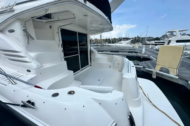 Slide: The Image of 2001 Sea Ray 400 Sedan Bridge yacht docked at marina, showcasing spacious deck and sleek design. - 8