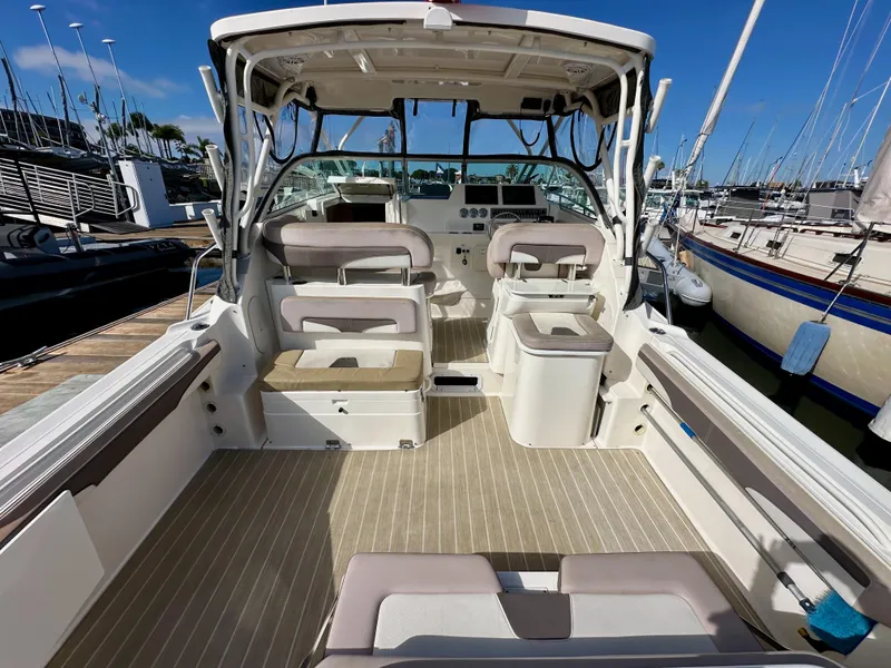 Slide: The Image of 2018 Wellcraft 290 Coastal boat interior with seating and helm, docked at marina. - 12