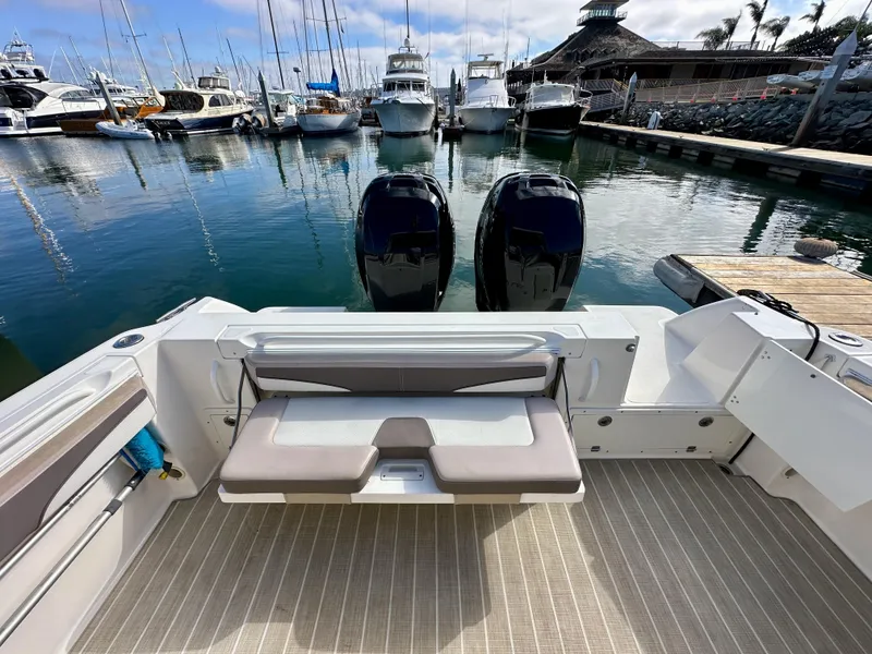 Slide: The Image of 2018 Wellcraft 290 Coastal boat at marina, featuring dual outboard engines and spacious seating. - 15