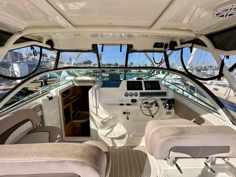 Slide: The Image of 2018 Wellcraft 290 Coastal boat interior with helm, steering wheel, and cabin view. - 18